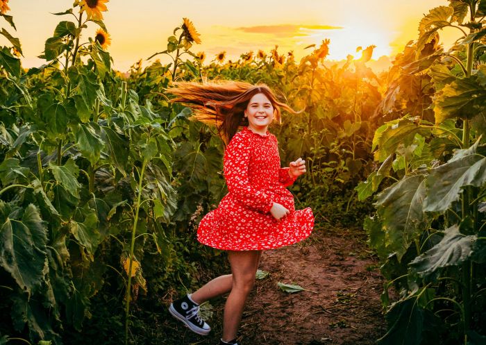 Girl running through a field of sunflowers at Hunter Valley Sunflowers, Hunter Valley